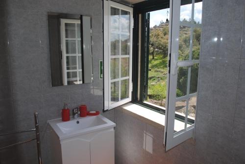 une salle de bain avec un lavabo blanc et une fenêtre dans l'établissement Moradia Familia Escoto, à Monsanto