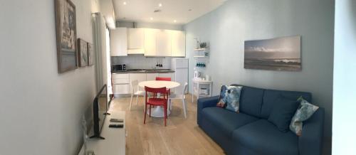 a living room with a blue couch and a kitchen at Casa Celeste in Viareggio