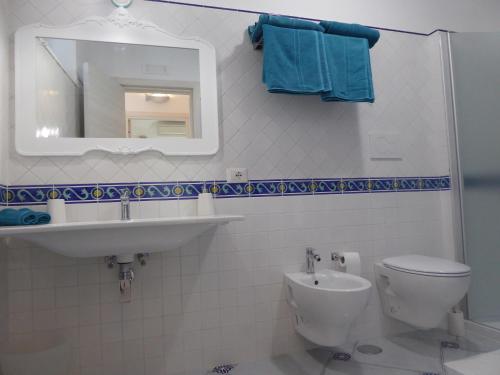 bagno con servizi igienici, lavandino e specchio di Casa Lara 2 a Positano