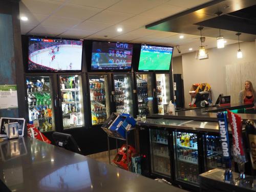 a bar with several video game machines in a store at The Cavalier Inn in Winnipeg