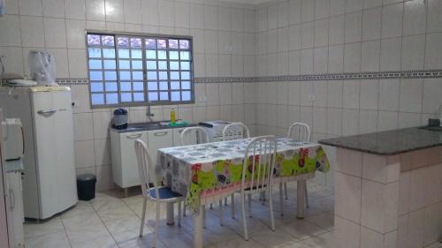a kitchen with a table and chairs and a refrigerator at hospedagem simples in Arapongas