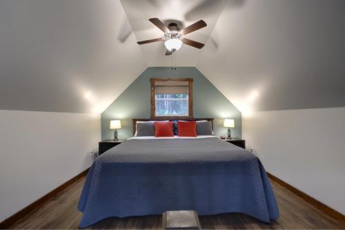 a bedroom with a blue bed with a ceiling fan at Bambury's Hillside Chalets in Rocky Harbour