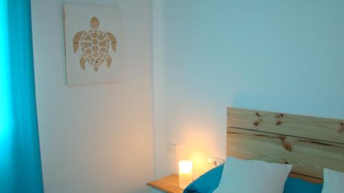 a bedroom with a bed and a candle on a table at The Beach House in El Médano