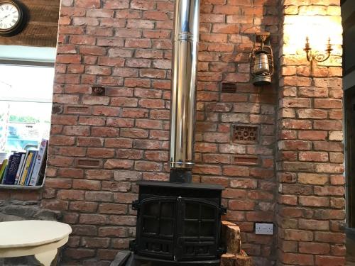 a brick wall with a stove in a room at Tracey's Farmhouse Cottage in Belfast