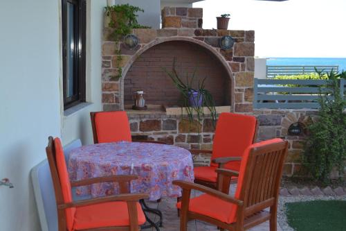 a table with red chairs and a brick oven at Noufaro studios in Karfas
