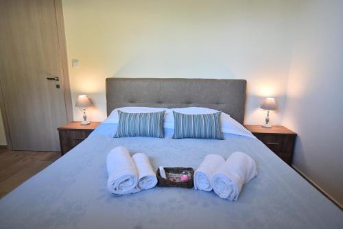 a bedroom with a bed with towels and two lamps at Searockhouse in Paleo Tsifliki