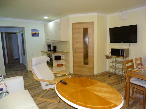 ein Wohnzimmer mit einem Tisch und einer Küche in der Unterkunft Ferienwohnung Altstadt Löbau in Löbau