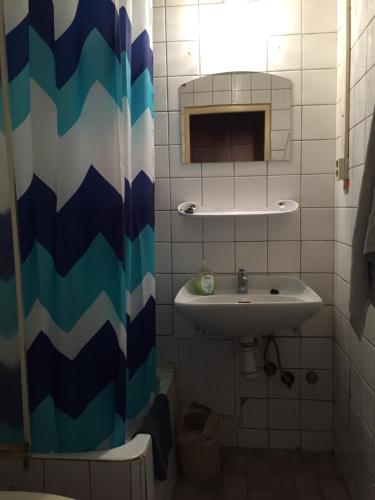 a bathroom with a sink and a shower curtain at Šariš rooms in Prešov