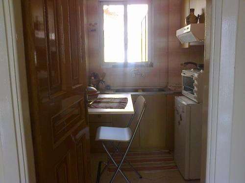 eine kleine Küche mit einem Tisch und einem Stuhl darin in der Unterkunft Christo in Athen