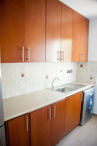 una cucina con mobili in legno e un lavello di Villa Infinite Blu a Paphos