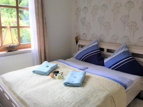a bedroom with a bed with blue towels on it at Haus am Wald Klingberg in Klingberg