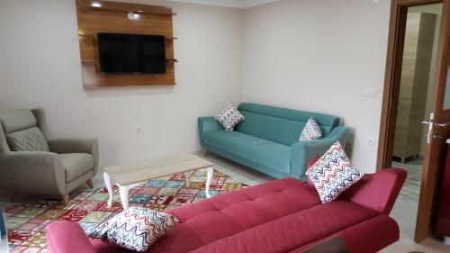 - un salon avec un canapé rouge et une télévision dans l'établissement Uzungol Comfort Residence, à Uzungöl