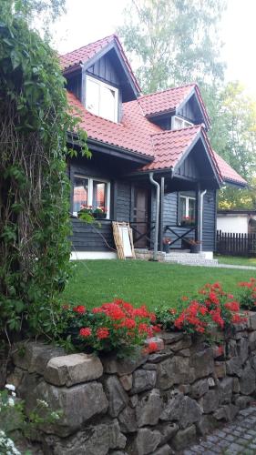 una casa con una pared de piedra y algunas flores en Willa pod lasem en Szklarska Poręba