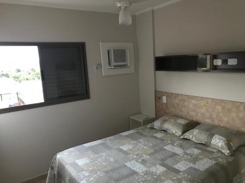 a bedroom with a bed and a window at Apartamento Villagio in Olímpia