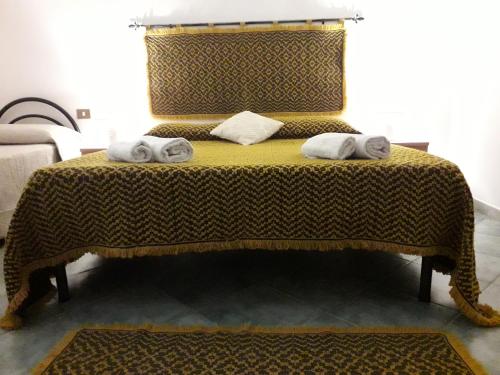 a bedroom with a bed with two towels on it at Agriturismo Quattro Mori in Porto Torres