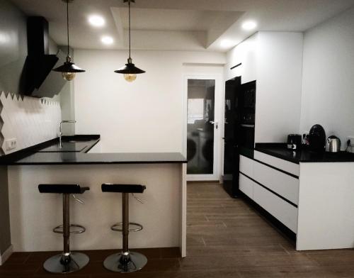 a kitchen with a counter and two bar stools at Apartamento Rami in Alicante