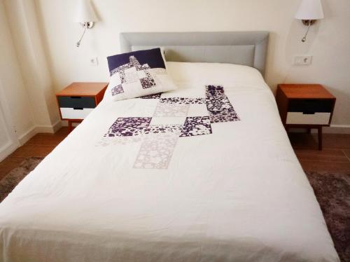 a bedroom with a white bed with a quilt on it at Apartamento Rami in Alicante