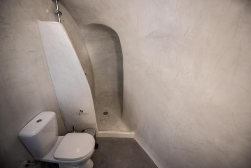 a small bathroom with a toilet in a hallway at Caves 1880 in Oia