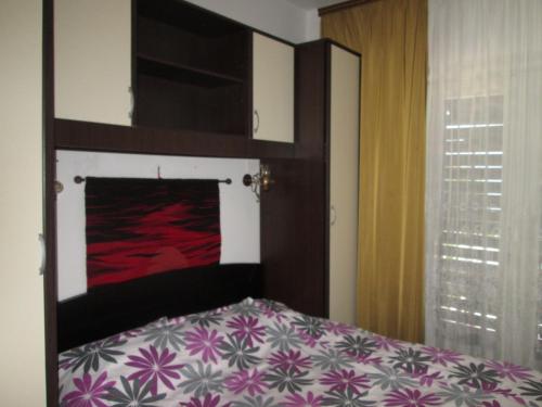 een slaapkamer met een bed met een paarse en witte sprei bij Apartment Ana in Novi Vinodolski