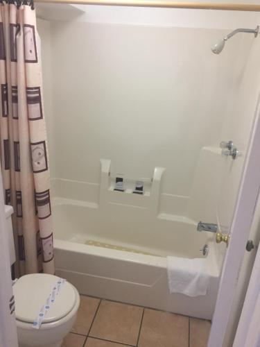La salle de bains est pourvue d'une baignoire blanche et de toilettes. dans l'établissement Rivers Inn, à Fort Madison