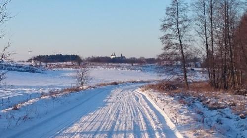 a snow covered road with tracks in the snow at Willa Bobrowa Dolina in Wójtostwo