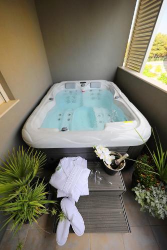 a jacuzzi tub in a room with plants at Dioniz in Zadar
