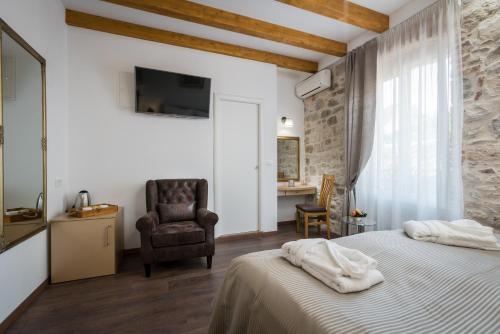 a bedroom with a bed and a chair and a television at ID Regal Residence in Split