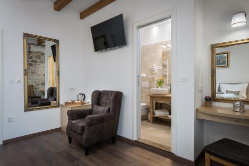 a living room with a chair and a mirror at ID Regal Residence in Split