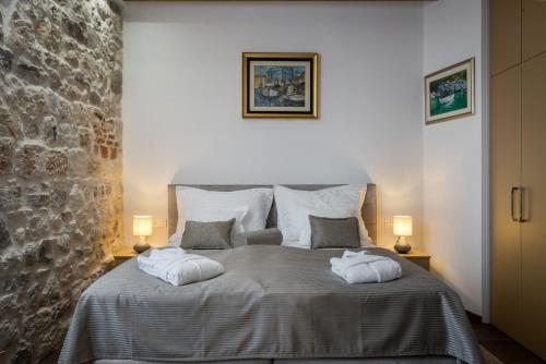 a bedroom with a bed with two pillows on it at ID Regal Residence in Split
