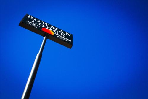 a street sign on a pole against a blue sky at Bowman Lodge & Convention Center in Bowman