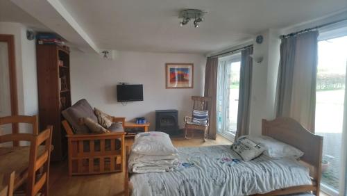 Schlafzimmer mit einem Bett, einem TV und einem Fenster in der Unterkunft Rebels Hide -Self check in rooms in Penrith