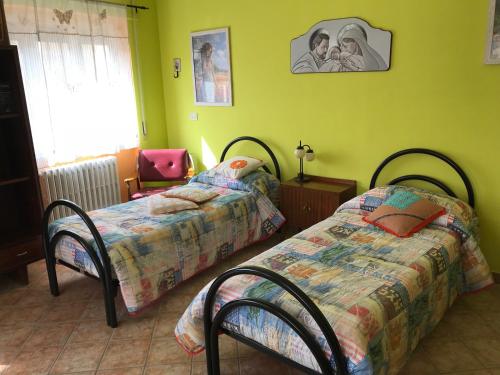 Un dormitorio con 2 camas y una silla. en La terrazza del dottore en Pescolanciano