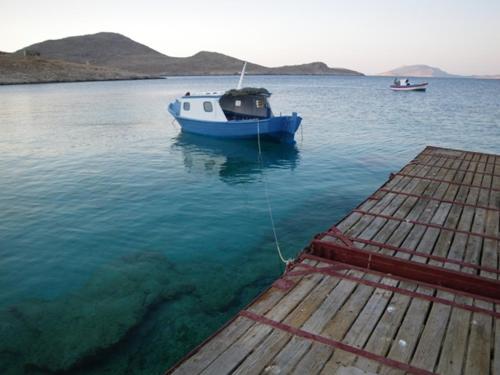 a blue boat in the water next to a dock at Cohili Villa in Halki
