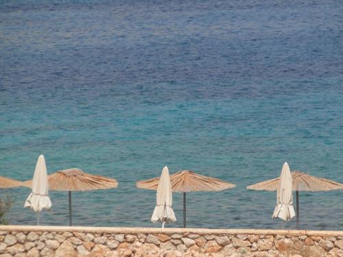 a group of umbrellas on the beach near the water at Cohili Villa in Halki