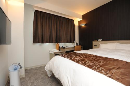 a hotel room with a large bed and a television at Hotel Sunriver Shimanto in Shimanto
