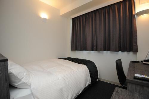 a hotel room with a bed and a window at Hotel Sunriver Shimanto in Shimanto