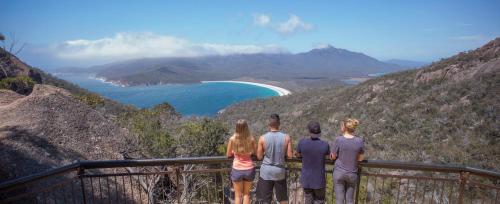 a group of people standing on a ledge looking at a mountain at YHA Hobart Central in Hobart