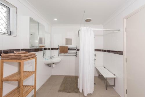 a bathroom with a sink, toilet and bathtub at Moore Park Beach Motel in North Coast