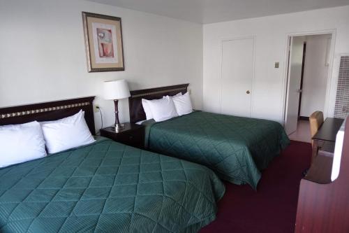 a hotel room with two beds with green sheets at Discovery Inn - Eureka in Eureka