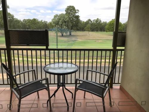 a table and chairs on a balcony with a view of a golf course at Emerald Executive Apartments in Emerald
