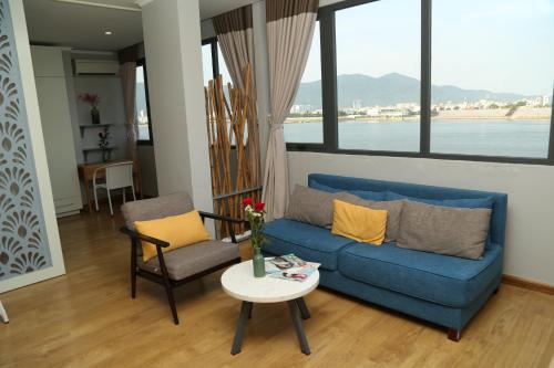 sala de estar con sofá azul y mesa en KaKa Hotel Han River, en Da Nang