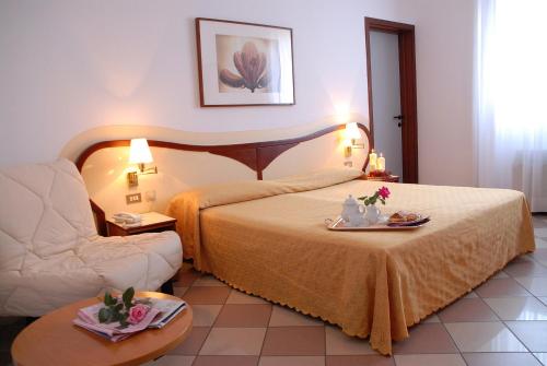 una camera d'albergo con letto e divano di Hotel La Fenice a Formigine