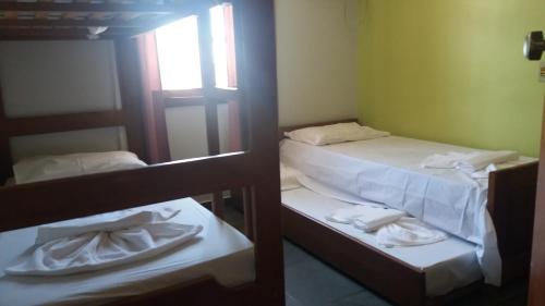 2 literas en una habitación con toallas. en Condomínio Taperapuã Praia Village, en Porto Seguro