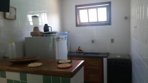 a kitchen with a wooden counter top and a window at Condomínio Taperapuã Praia Village in Porto Seguro