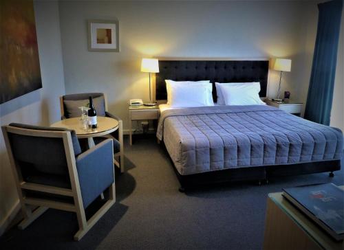 a hotel room with a bed and a table and a chair at Park Ridge Retreat in Gerringong