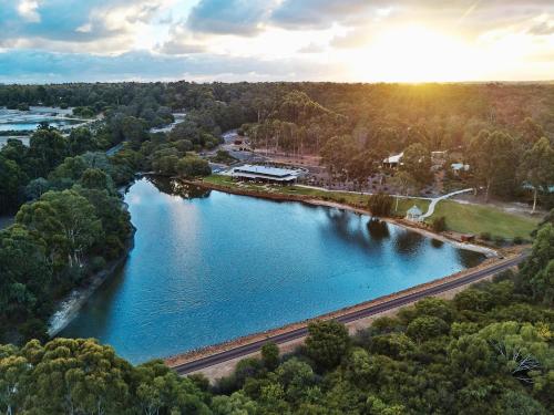 an aerial view of a river with the sun setting at Eight Willows Retreat in Margaret River Town