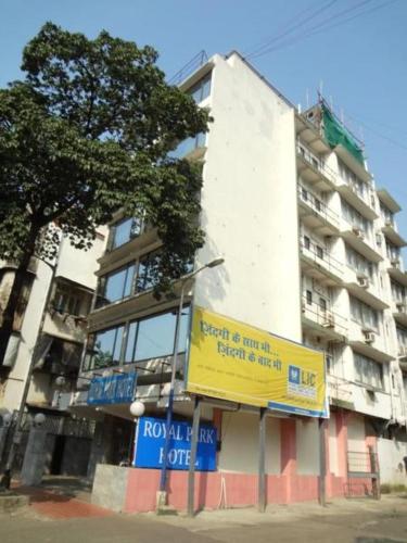 a tall building with a yellow sign in front of it at Royal Park Hotel Dockyard in Mumbai