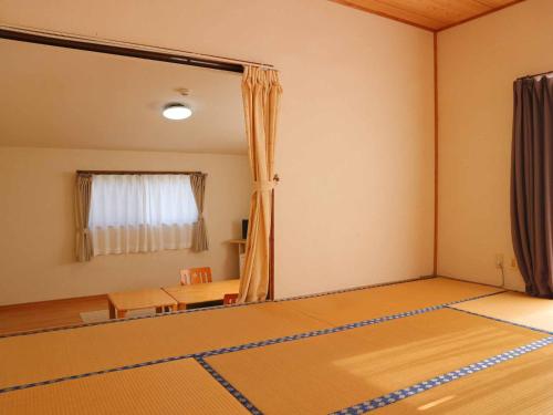 an empty room with a table and a mirror at Minshuku Manten in Yakushima
