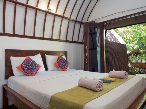 Un pat sau paturi într-o cameră la Gili Turtle Beach Resort