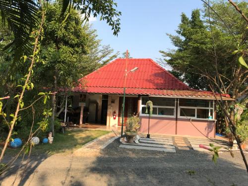 a house with a red roof at Green Leaf Resort in Surin